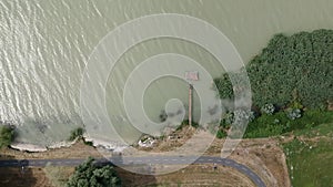 Wooden pier on the shore of Balaton lake with bicycle path passing by the water