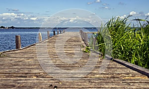 Wooden pier stretching into the steinhuder meer under cloudy sky photo