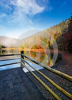 Wooden pierce fence on a lake in fog