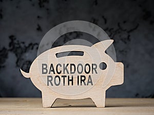 Wooden piggy bank with words backdoor Roth IRA. photo