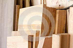 Wooden pillars and thick boards in the furniture workshop are ready to work joiner, selective focus