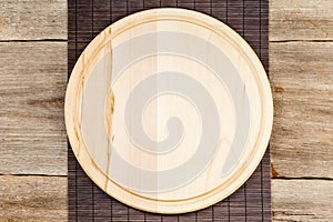 Wooden pizza board over grunge rustic background