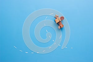 wooden plane performs a loop across the surface of a blackboard.