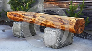 a wooden plank bench resting on a sturdy concrete base in a realistic photograph.
