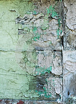 Wooden plank wall with cracked old green paint.