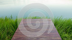 Wooden planks background with green grass on river