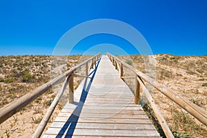 Wooden planks footbridge to the blue sky horizon