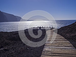 Wooden planks path leading to the sea shore with view on hight l