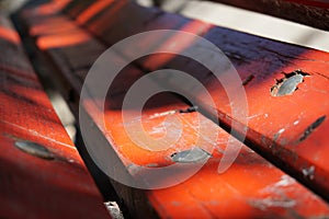 Wooden planks of a red bench in the sidewalk alongside Lana river, Tirana, Albania