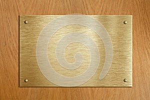 Wooden plaque with gold or brass plate