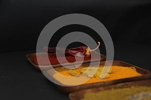 A wooden plate with paprika and dried chili