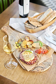 Roasted octopus BBQ and Baked potato with a glass of Grapa. Wooden plate. Restaurant menu photo