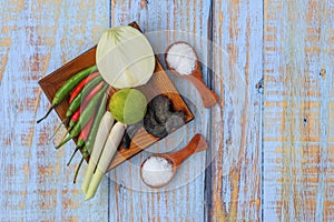 Wooden plate with salt, msg,ginger,garlic,onion,key lime, chilies, and lemongrass