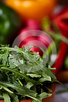 Wooden plate with vegetables for a vegetarian salad on white textured background, close-up, selective focus