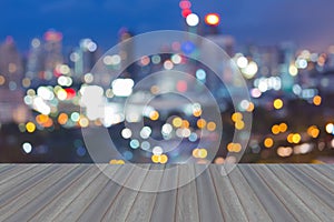 Wooden platform with abstract blurred bokeh city lights skyline, twilight backgroun