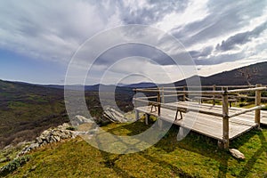 Wooden platform to contemplate the views of the green mountain landscape