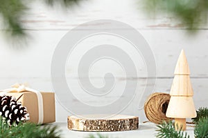 Wooden podium with branches of Christmas tree, gift and cone on vintage wood background. Concept scene stage showcase, product,