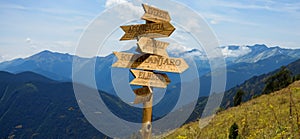 wooden pointer with directions to mountain peaks with indications of the height of the mountains and the distances to them