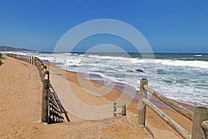 Wooden Pole Barrier on Beachfront Against Coastal Landscape