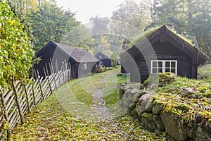 Wooden pole fence and old cottages in an old rural village