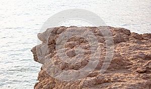 Wooden pole of a rope fence near the sea