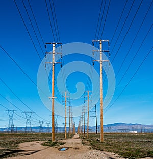 Wooden poled power lines run in parallel back to hills in the background