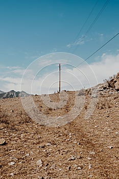 Wooden poles with electrical wires in mountainous region. Spread of electricity to hard-to-reach areas