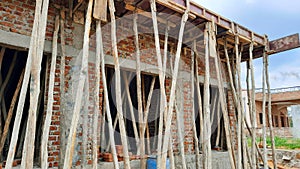 wooden poles under rcc roof on construction site in India