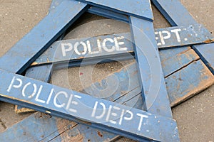 Wooden police barrier with white stenciled lettering