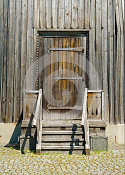 Wooden porch with and door. Openwork platbands