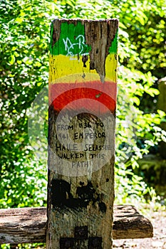 A wooden post next to a bench in tribute to Haile Selassie in the city of Bath