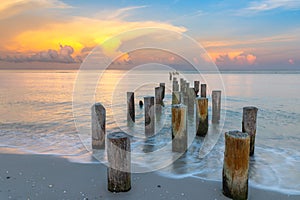 Wooden posts on Naples Beach at sunset, Florida