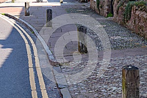 Wooden posts set in the pavement at Nether Stowey in Somerset to prevent cars parking or driving on the pavement