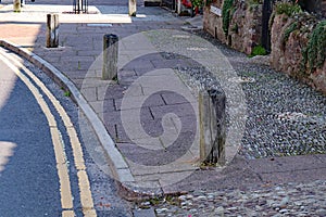 Wooden posts set in the pavement at Nether Stowey in Somerset to prevent cars parking or driving on the pavement