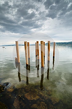 Wooden posts on the shores of a lake on an overcast sky