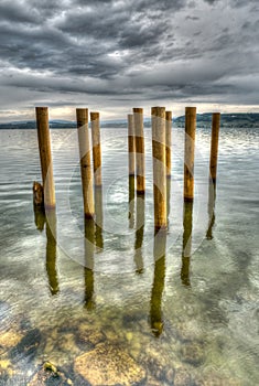 Wooden posts on the shores of a lake on an overcast sky