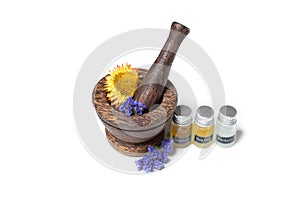 Wooden pounder with bottles of organic oils and flowers photo