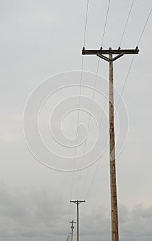 Wooden power utility pole with transformers and cables.