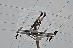 Wooden power utility pole with transformers and cables.