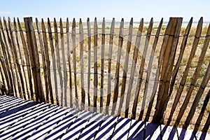 Wooden protective barrier of the dune leading to the beach sea access walkway on atlantic ocean horizon in Jard sur Mer in france