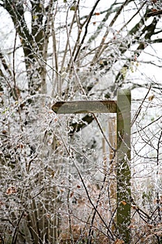 Wooden Public Footpath signpost with snow or hoar frost in winter