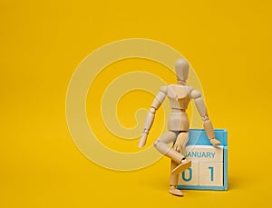 Wooden puppet and calendar with the date the first of September on a yellow background