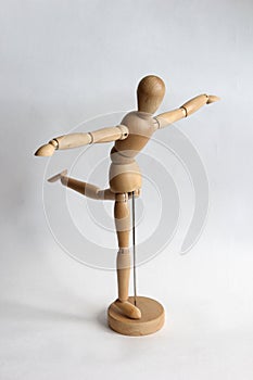 Wooden puppet man doing exercises