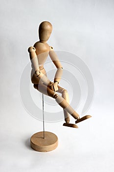 Wooden puppet man sitting and thinking
