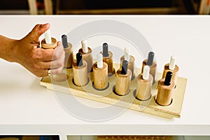 Wooden push-buttons in a montessori classroom pulsed by the teacher to demonstrate performance