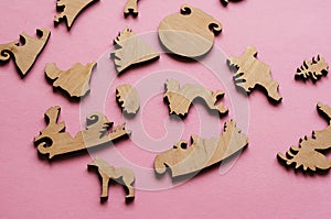 Wooden puzzle on a pink background. Puzzle pieces in the shape o