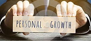 Wooden puzzles with the word Personal growth in the hands of a businessman. Self-improvement of skills, knowledge, personal