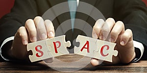 Wooden puzzless with the word SPAC - Special purpose acquisition company. Simplified listing of company, merger bypassing stock photo