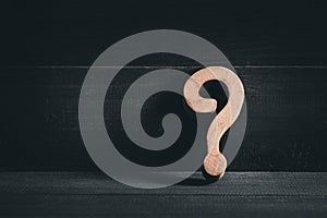 Wooden question mark on wood table background. Problem solving concept