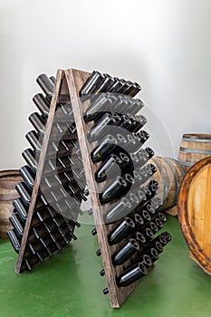 Wooden rack with empty wine bottles without labels